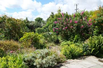 The sunny patio is surrounded by the pretty gardens.