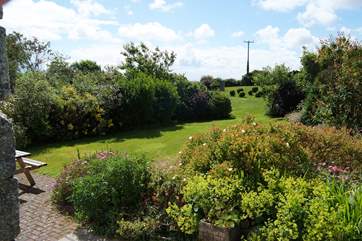 The view from the patio showing the lawned pathway leading you to the large area of grass in the rear garden-area.