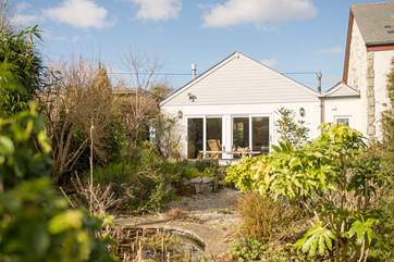 Looking back to the sitting-room from the garden, which includes a pretty covered pond.
