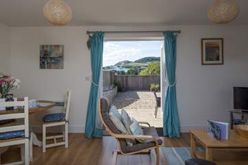 The cheerful open plan living area opens onto the sunny patio, with wonderful views of Golden Cap.