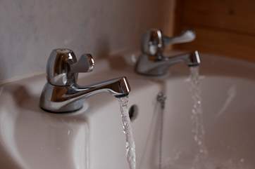 The shower-room is complete with a wash-basin and proper flusing toilet.