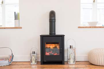 A modern electric stove warms the sitting-area.