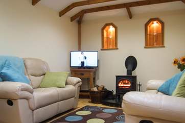 Two recliner sofas piled with cushions allow you both to stretch out and relax.