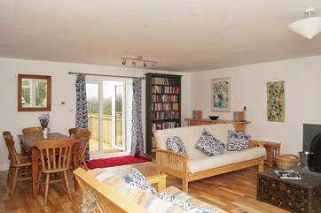 The living-room has two large comfortable sofas facing the wood-burner, and patio doors at each side.