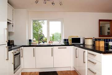 The white high-gloss kitchen is very well-equipped....