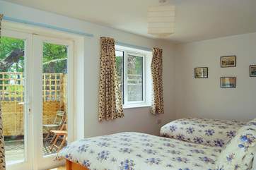The twin bedroom (Bedroom 2) has glazed doors opening out onto the front patio.