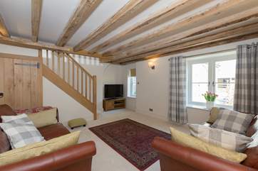 The sitting room overlooks the courtyard and the stairs lead straight up into one of the spacious double bedrooms.