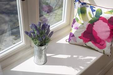 A deep windowsill looking out over the woodlands on the other side of the lane.
