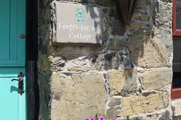 Hanging baskets and tubs at the front of the cottage are full of colour in summer.