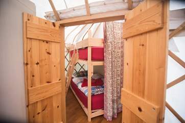 Double doors lead into the attached yurt which houses the bunk beds and the shower-area.