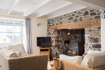 The sitting-area, at the front of the cottage with cosy wood-burner, leads through to the dining-area.