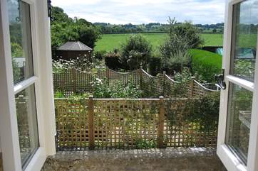 The cottage is in an edge of village setting and this is the view from one of the upstairs windows - overlooking the Owner's beautiful gardens and to the countryside beyond.