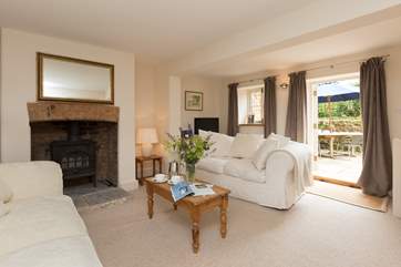 The living-room has French windows out to the enclosed courtyard garden at the back of the cottage.
