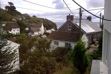 The view from the bedroom across cottage rooftops to the sea.