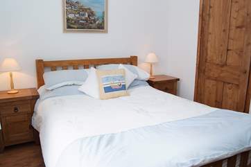 The bedroom is a comfortable haven with both modern and antique wood furniture.