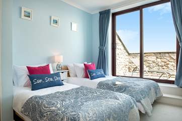 The delightful twin bedroom with a sliding door leading out to the balcony.