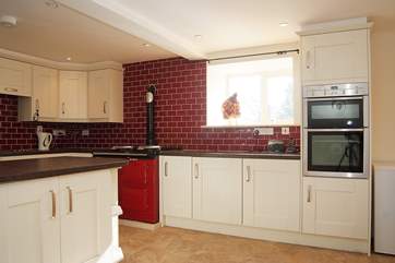 The big kitchen/dining-room is warmly decorated in cream and red.