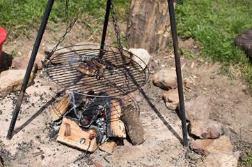 Sizzle a sausage on the firepit barbecue.