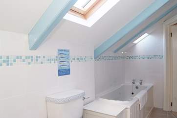 The bathroom is long and thin but provides both a bath and shower.