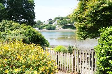 At the bottom of the garden a gate leads out to a lower patio with river access.