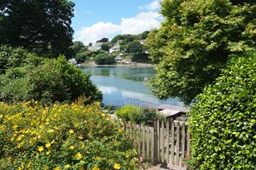 At the bottom of the garden a gate leads out to a lower patio with river access.