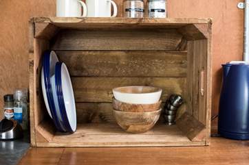 Rustic wooden bowls and enamel crockery complement the glamping theme.