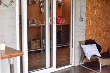 From the living-area a patio door leads into the wooden annexe with its kitchen-area with fridge, sink and a double ring camping gas stove. As well as the cloakroom and shower-room.