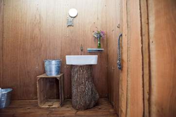 The very interesting cloakroom with its wash-basin on a tree trunk!