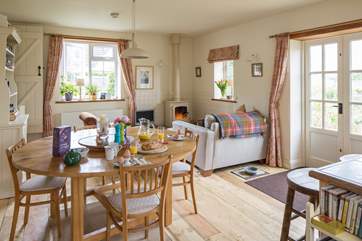 The cottage has a lovely welcoming open plan living area. There is a wood-burner in one cosy corner and French windows to the garden.