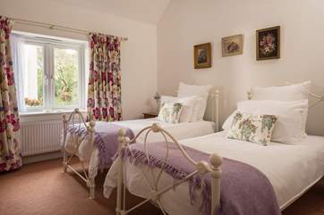 The comfortable twin-room is tastefully furnished with ornate beds and pine furniture.
