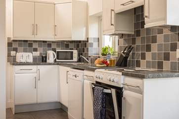 The kitchen is well-equipped and flows through to the utility-room and cloakroom beyond.