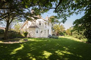 The house is surrounded by lovely gardens.