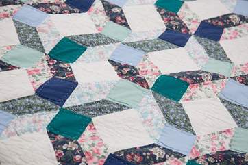 A pretty patchwork quilt on the bed.