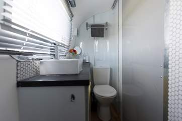 There is a wash-basin with hot and cold running water.