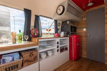 The kitchen is very well-equipped and features a funky red Smeg fridge.