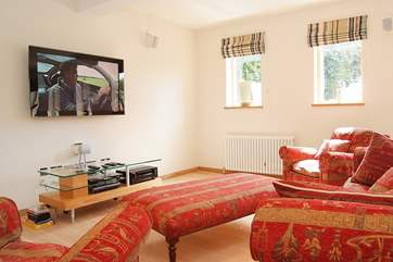 The family-room has a 50 inch wall-hung plasma TV with a surround sound system.