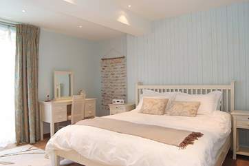 Tranquil colours in Bedroom 3 and doors out to the balcony.