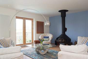 The sofas in the open plan living-room are set around a ceiling-hung Focus wood fire.