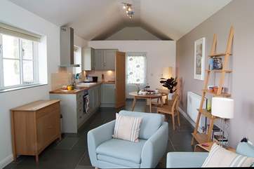 The light and spacious living-room is beautifully furnished in calm, restful colours with thoughts of Scandinavia.