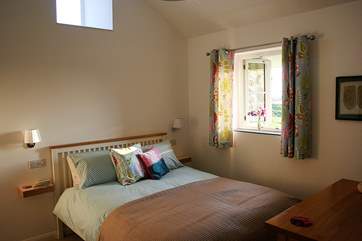 The beautifully furnished bedroom with those wonderful countryside views and en suite shower-room.