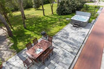 Looking down from the balcony to the dining terrace and hot tub outside.