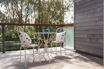 The balcony outside the second floor living-room looks out over the terrace and woodland beyond.