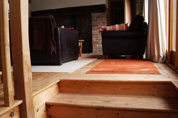 There are wooden stairs leading from the kitchen to the sitting-room.