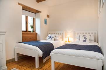 The twin bedded room has lovely crisp white linen and gentle reminders that you are so close to the sea.