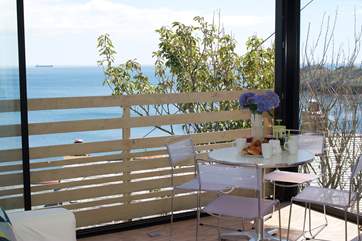 The ceiling to floor door opens to bring the outside in so you can enjoy breakfast with that amazing view and the sounds of the sea.
