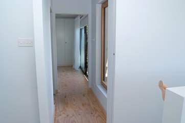 The ground floor hallway with the stairs on the right of the picture and the twin bedroom at the end.