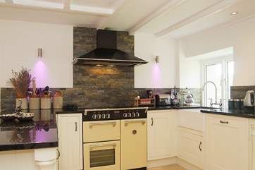 Granite work surfaces, an electric range cooker and colour-changing lights in the kitchen-area.