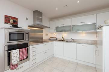 The sleek kitchen is very well-equipped - there is a separate utility-room too.