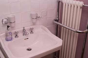 The bathroom in the cottage is gorgeously fitted out with a sink, bath and even radiators.
