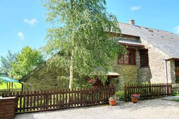 The front of this lovely cottage with the deck and garden to the left.